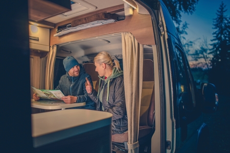 Couples and the RV Park Camping. Young Couples Planning Next Trip in the Motorhome.