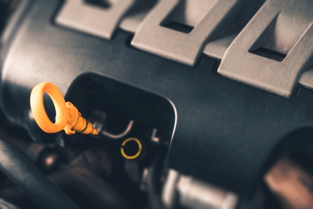 Car Engine Oil Check Photo Concept. Modern Car Engine Closeup on Dipstick