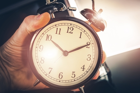 Time is Running Out. Large Classic Alarm Clock in a Hand.の写真素材