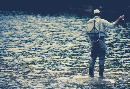 Fisherman Fishing in the Lake During Calm Summer Evening.の写真素材