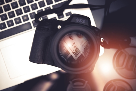 Digital Camera and Dollar Banknotes Reflection Inside the Lens and Laptop Computer.の写真素材
