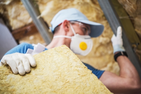 Mineral Rock Wool Insulating Concept Photo. Worker with Piece of Insulating Wool in Hands.の写真素材