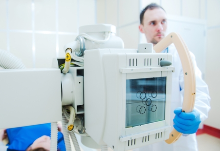 Hospital X Ray Scanner and the Scanning Caucasian Technician in His 30s. 