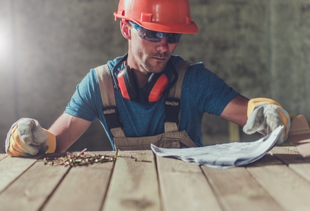 House Construction Contractor with Installation Documentation on the Wooden Table. Construction...