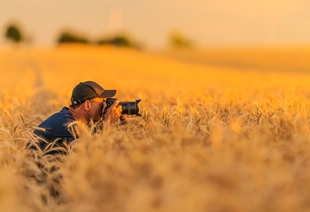 Nature Photographer in Action. Caucasian Senior Photographer Taking Pictures in the Middle of the...