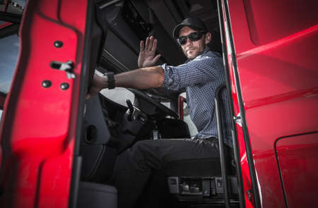 Tractor Trailer Truck Driver Leaving Warehouse and Heading the Road to Destination.