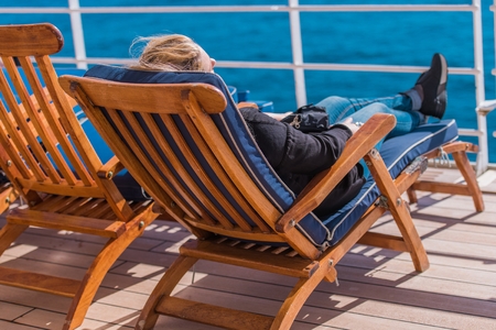 Caucasian Woman Relaxing on a Deckchair During Her Cruise. Sunny Weather.の写真素材