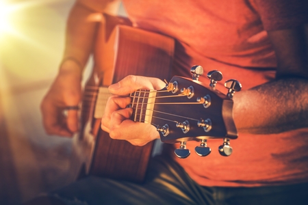 Mastering Acoustic Guitar. Caucasian Musician Playing on Guitar.