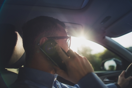 Unlawful Driving and Phone Talking in the Same Time. Safe Driving Concept with Caucasian Men in His...