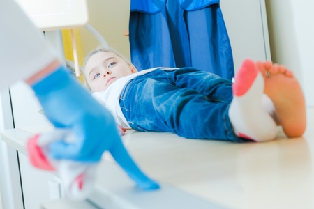 Little Caucasian Girl X Ray MRI Scan in the Hospital Testing Room. Doctor Talking and Preparing Child For the Test.の写真素材