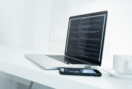 Web Application Developer Desk with Modern Laptop Computer and Website Source Code on Display....