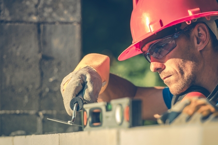 Caucasian Masonry Worker in Hard Hat. Construction Site Theme.の写真素材