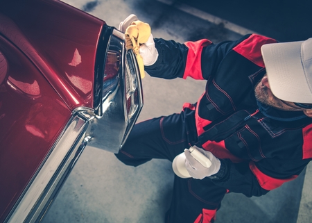 Caucasian Men in His 30s Detailing His Classic Car Using Body Protection Liquid. American Collectible Vehicle. Deep Automobile Cleaning.の写真素材