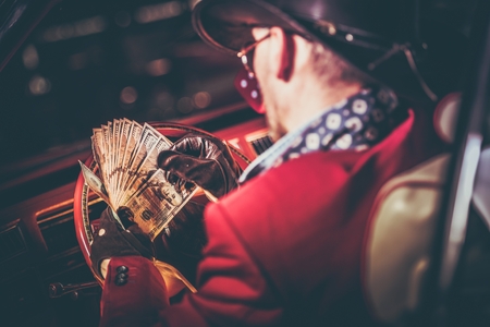 Lucky Casino Winner with His Cash Jackpot in Hands. American Cowboy and the Classic Car. Las Vegas...