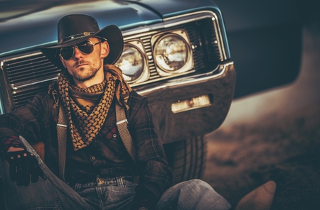 The Men of the Far West. Caucasian Western Wear Men in His 30s Relaxing in Front of His Classic Muscle Car. American West.の写真素材
