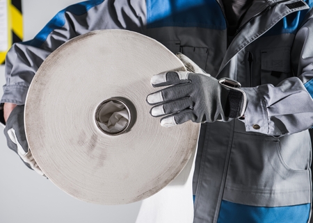 Worker with Large Roll of Industrial Use Paper. Closeup Photoの写真素材