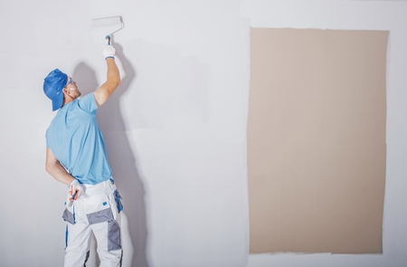 Room Painter at Work. Covering Darker Paint by Fresh and Lighter One. Apartment Renovation. Refreshing the Walls. Construction Theme.の写真素材