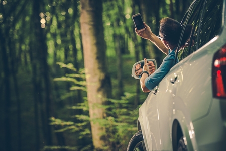 Caucasian Men in His 30s Looking For Cellphone Signal From Inside His Car.の写真素材