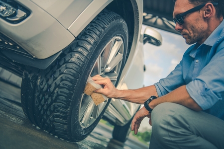 Alloy Wheels Hands Cleaning. Caucasian Men in His 30s Detailing His Vehicle in the Car Wash.の写真素材