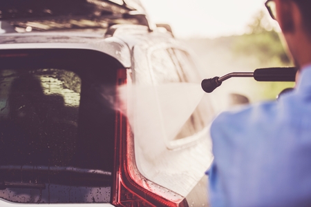 Men in the Car Wash Cleaning His Modern Sport Utility Vehicle. Auto Cleaning Station.の写真素材