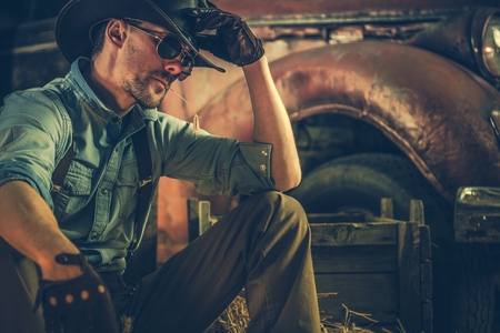 American Caucasian Rancher Resting in the Barn. Countryside Theme. Cowboy and the Country.の写真素材