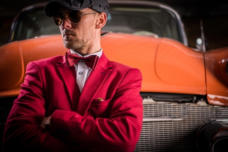 Classic Vehicles Collector. Elegant Caucasian Men Awaiting Classic Cars Auction.の写真素材