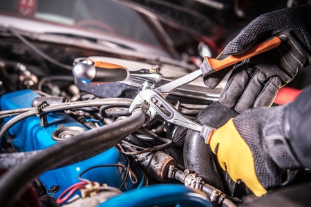 Car Mechanic Trying to Fix Gasoline Engine Problem. Automotive Industry Concept.の写真素材