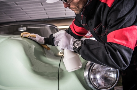 Men Cleaning His Car Body Using Professional Cleaner in Liquid. Vehicle Washing and Detailing Theme. Classic Car.の写真素材