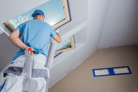 Caucasian Men Painting His Apartment. Construction Theme.の写真素材