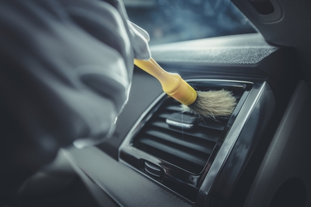 Detailed Car Cockpit Cleaning. Vehicle Detailing Concept. Removing Small Dirt From Vents.の写真素材