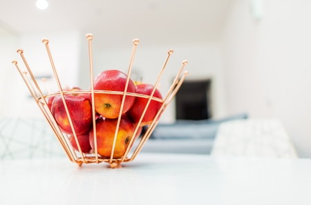 Metal Fruit Basket with Red Apples. Bright Modern Apartment Interior.の写真素材
