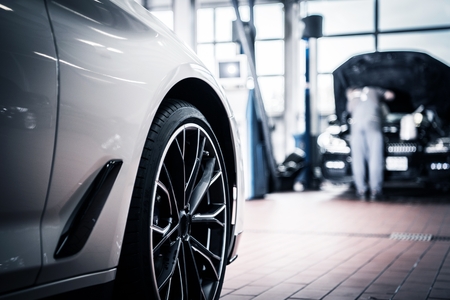 Auto Service and Vehicle Maintenance by Professional Technician in the Background. Automotive...
