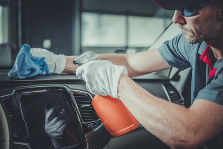 Clean Vehicle Interior. Caucasian Worker in His 30s Detailing Inside the Car.の写真素材