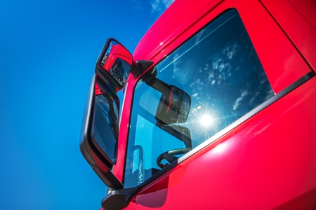 Red Modern Semi Truck Cabin Closeup. Trucking Industry. CDL Concept.
