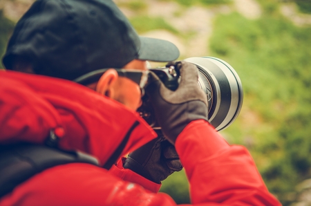 Telephoto Nature Photography. Caucasian Professional Photographer with Large Super Telephoto Lens Attached to Digital Camera.の写真素材