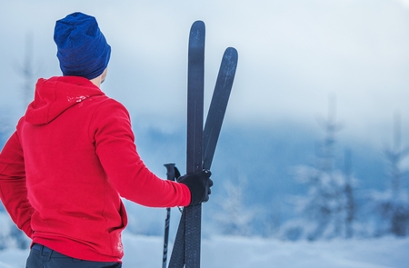 Winter Season Sports Theme. Caucasian Skier with Skis in Hand Closeup Photo.の写真素材