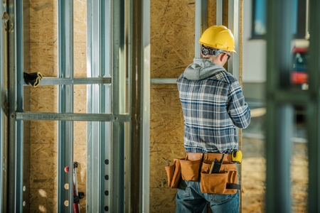 Metal Building Frame Construction Worker and His Job. Industrial Theme. Caucasian Men in His 30s.