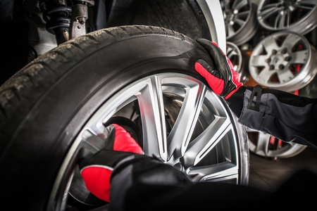 Balancing Vehicle Wheels. Modern Car in the Auto Service. Professional Worker Removing Wheel From...