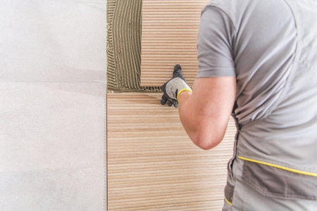 Caucasian Worker Installing Modern Bathroom Tiles. Closeup Photo.の写真素材