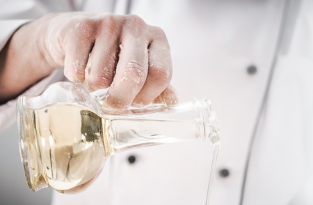 Caucasian Kitchen Chef Using Virgin Olive Oil in a Kitchen. Restaurants and Dinning Industryの写真素材