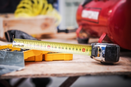 Apartment Remodeling Theme. Measuring Tape and Other Tools Handful in Time of House Renovation.