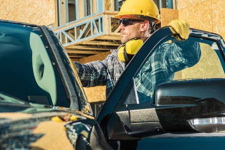 Construction Business Owner. Caucasian Supervisor in His 30s Wearing Yellow Hard Hat and His Company...