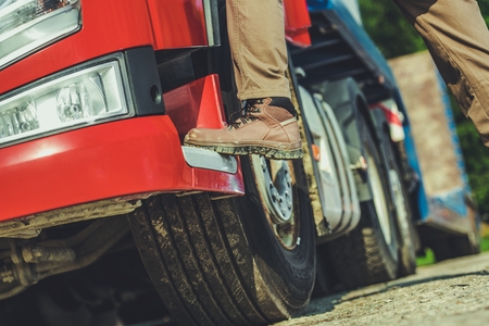 Truck Driver and His Job Conceptual Photo of Men Getting Into Semi Truck. Leg Closeup....