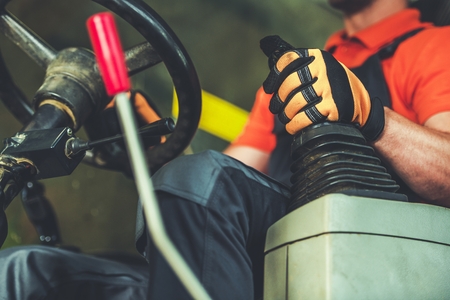 Bulldozer Operator. Caucasian Heavy Equipment Driver with Hand on a Joystick Inside Vehicle Cabin....