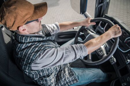 Young Caucasian Semi Truck Driver in His 30s Inside Modern Vehicle Cabin. Transportation Industry.の写真素材
