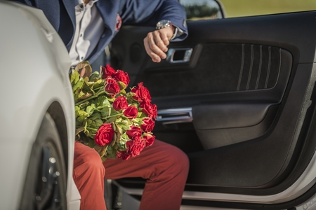 Caucasian Men with bunch of Red Roses Awaiting His Lover While Seating in a Sporty Modern Car....