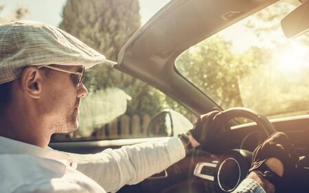 Young Caucasian Men in His 30s Driving His New Convertible Car During Hot and Sunny Summer Day. Vacation Road Trip.の写真素材