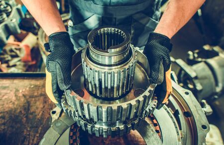 Heavy Duty Mechanic with Industrial Grade Vehicle Part in Hands.の写真素材