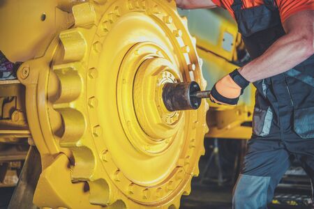 Bulldozer Pro Mechanic. Caucasian Construction Machines Technician Rebuilding Bulldozer.の写真素材