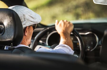 Caucasian Men in His 30s Driving Modern Convertible Car During Hot Summer Day.の写真素材